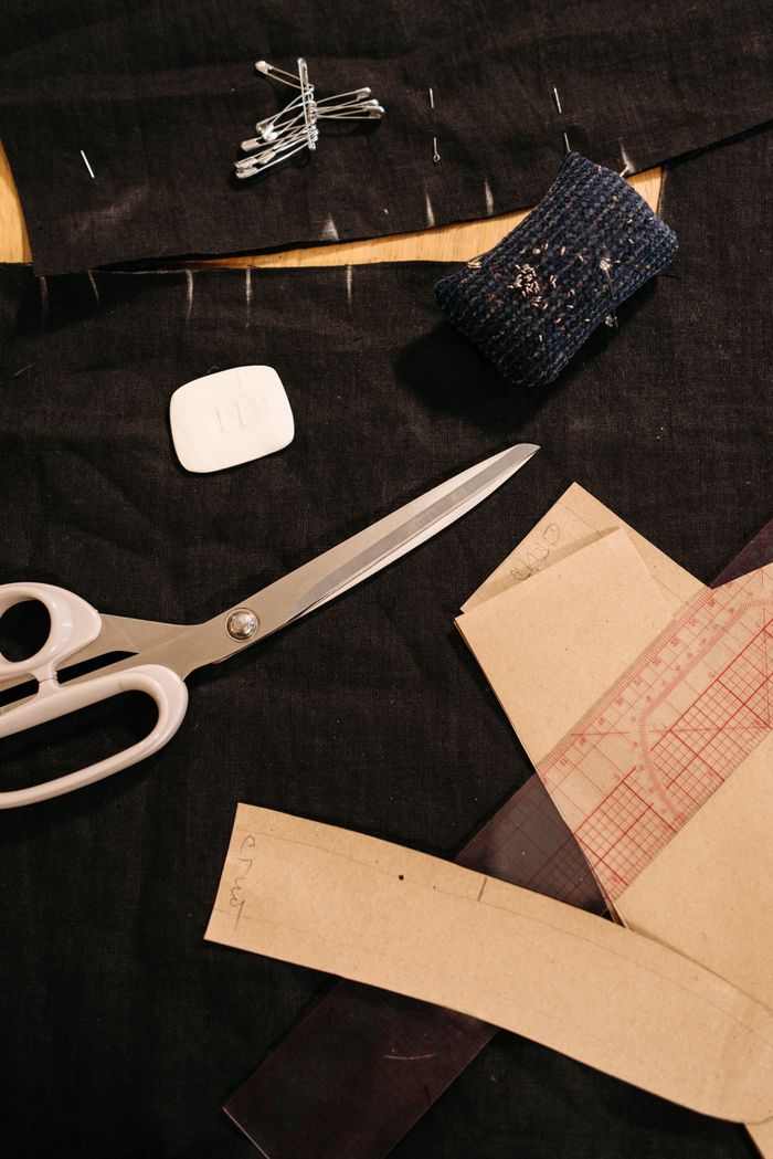 A top view of sewing tools and fabric arranged on a workspace, ideal for tailoring projects.